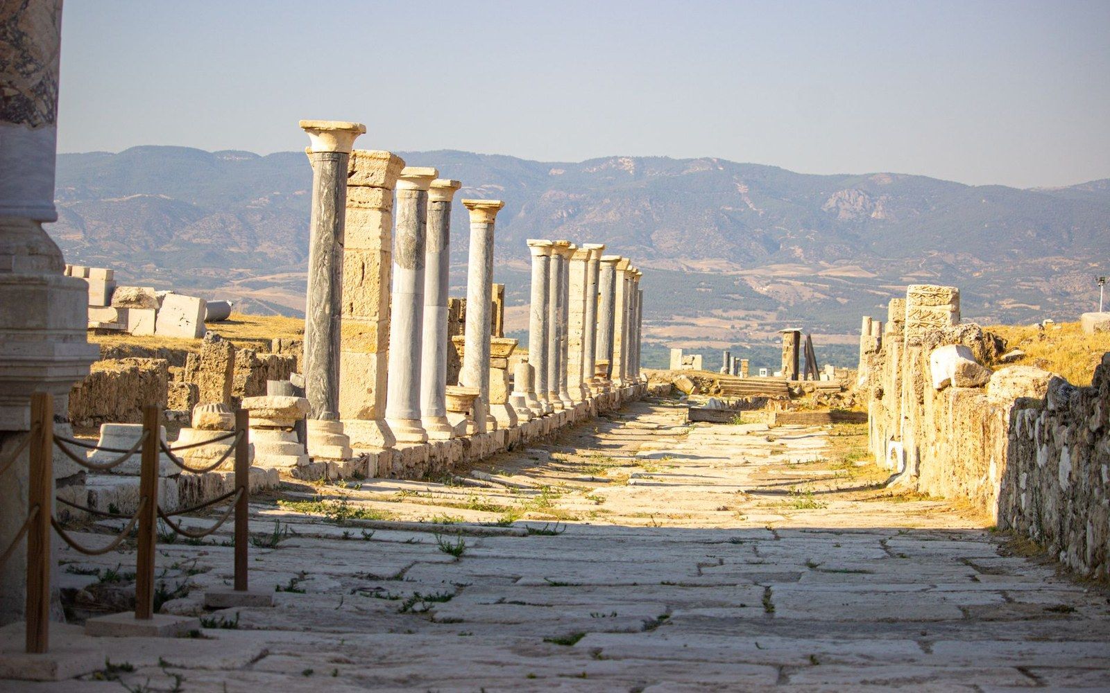 A colonnaded street of a ruined classical city, paving stones still in place